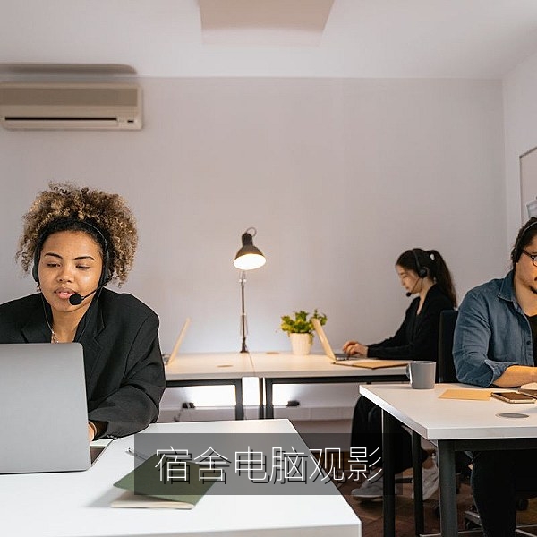 宿舍书桌上用电脑和高清电影播放器观看影片